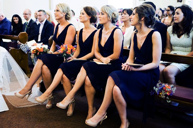 bridesmaids in short navy dresses in church