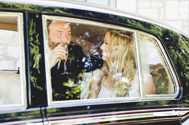 bride and groom in wedding car with Champagne