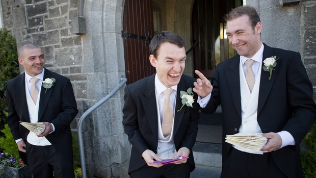 groom and groomsmen laughing outside church