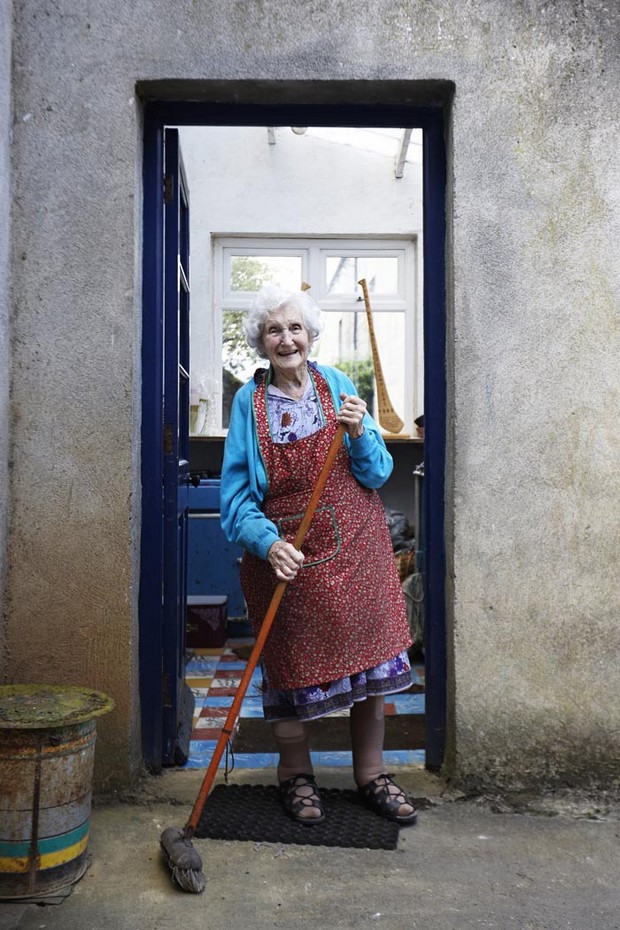 smiling elderly irish woman with sweeping brush