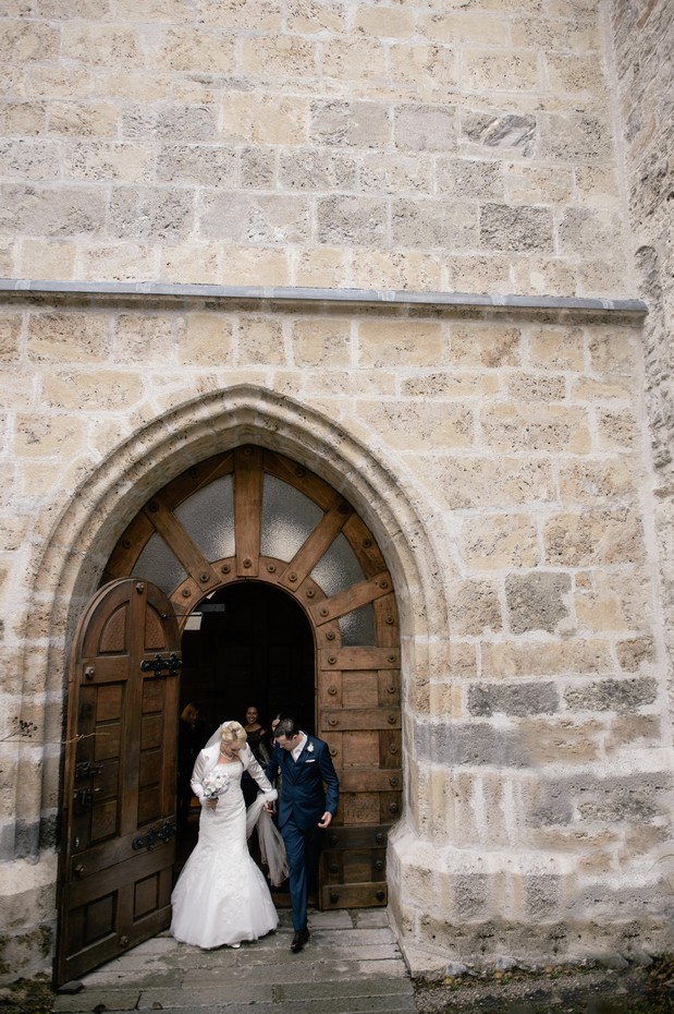 bride groom against exposed brick church