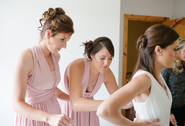 bridesmaids-helping-bride-with-dress