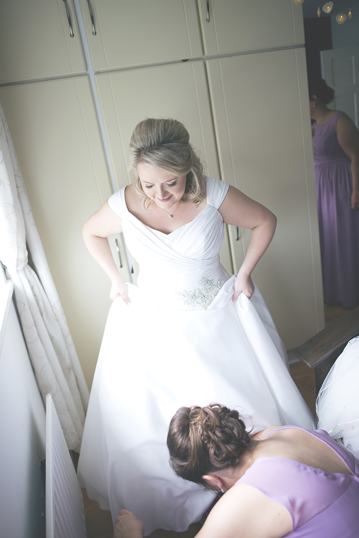 11-bridesmaid-helping-bride-dress-shoes-wedding-morning-ready