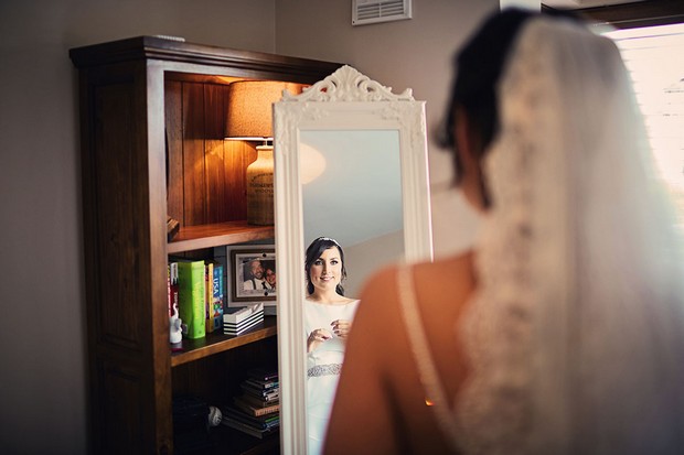 16-bride-looking-mirror-getting-ready-wedding-morning-weddingsonline
