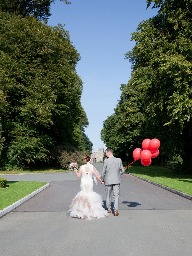 bellingham-castle-real-wedding-bride-and-groom-with-red-balloons