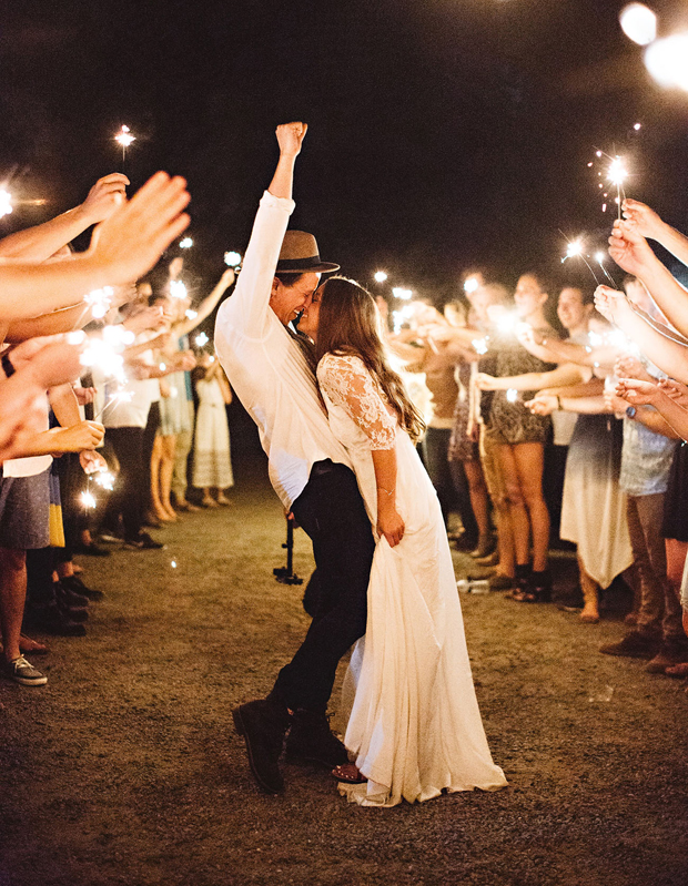couple-surrounded-by-friends-with-sparklers-wedding