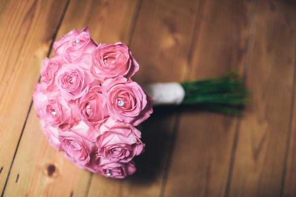 pink bouquet lying on wooden floor