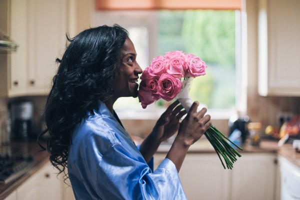 bride in blue dressing gown smell pink bouquet