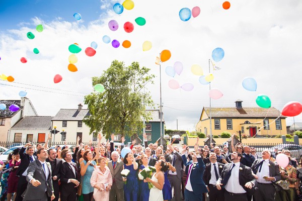 group shot colourful balloon release wedding