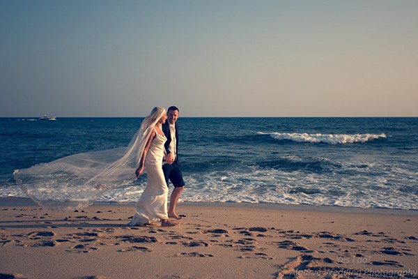 bride and groom walking along beautiful beach